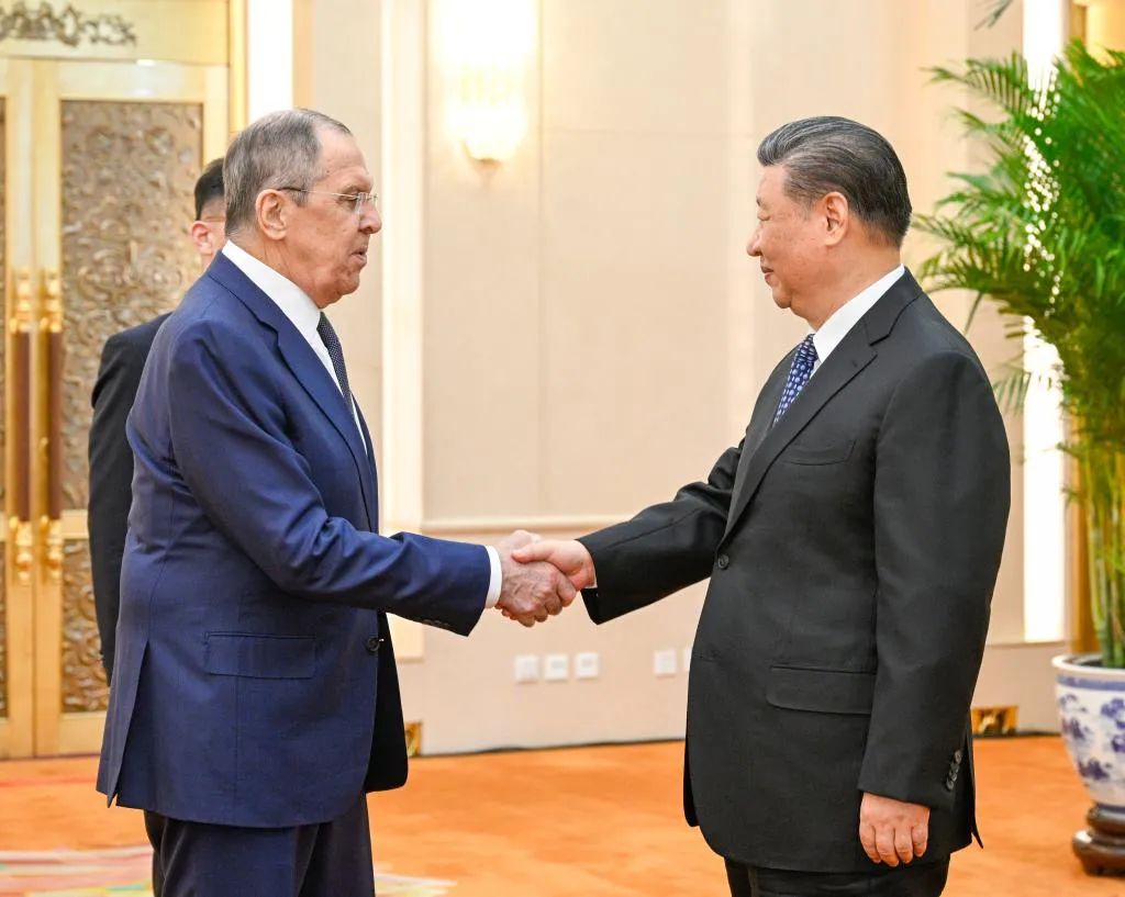 President Xi Jinping shakes hands with Russian Foreign Minister Sergey Lavrov in Beijing on Tuesday. [Photo by Li Xueren / Xinhua]